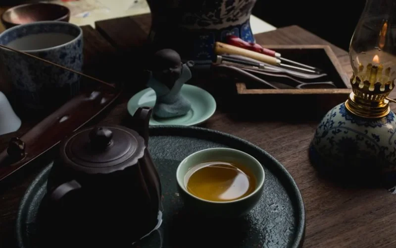 High quality Chinese tea tins and a glass teapot with green tea leaves.