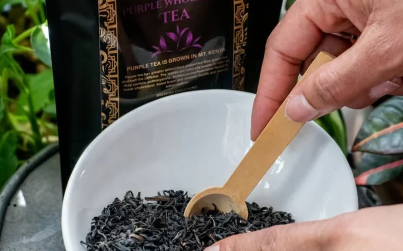 Various loose leaf teas, hibiscus petals, and ginger slices arranged near ceramic cups.