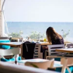 A cup of specialty espresso on a stone table overlooking the Adriatic coast.