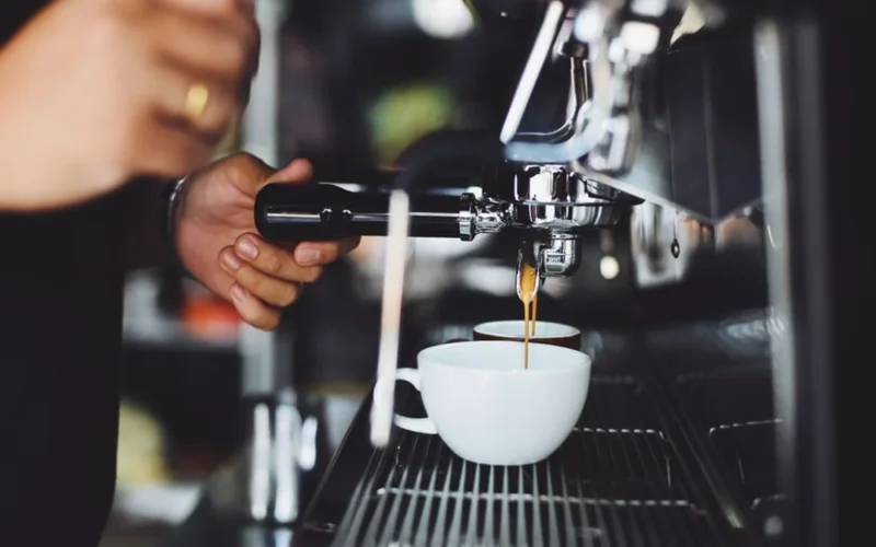 Comparison of a traditional chrome E61 espresso machine and a modern black single boiler machine.