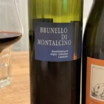 Two glasses of mature Italian red wine on a dark wooden surface.