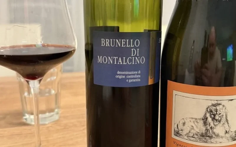 Two glasses of mature Italian red wine on a dark wooden surface.