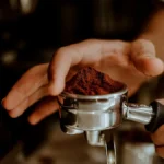 Close up of espresso pouring from a bottomless portafilter showing uneven flow patterns.
