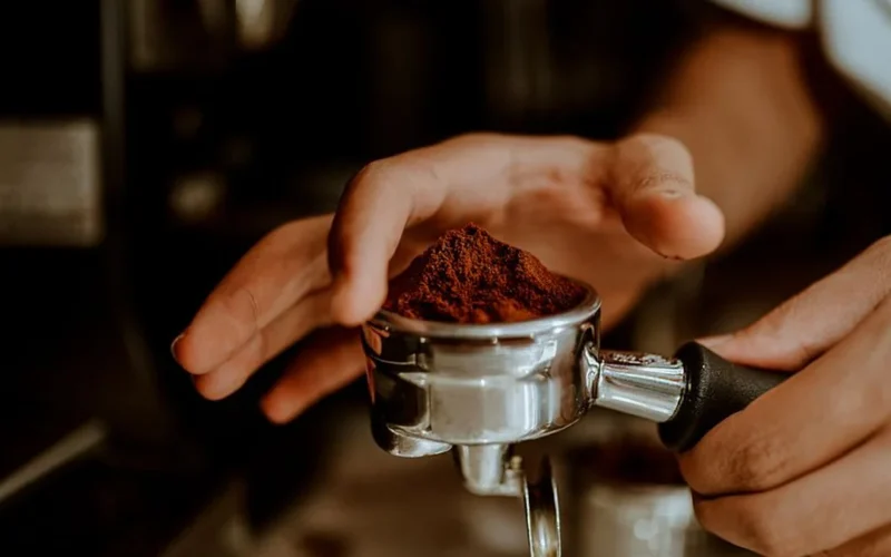 Close up of espresso pouring from a bottomless portafilter showing uneven flow patterns.