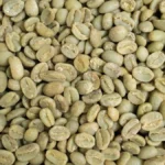 Raw green coffee beans mixed with various international paper currency on a dark surface.