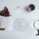 Pour over coffee dripping into a glass carafe filled with ice cubes.