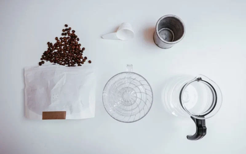Pour over coffee dripping into a glass carafe filled with ice cubes.