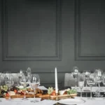 Two glasses of red wine sitting on a dark textured surface representing Barolo and Etna Rosso.