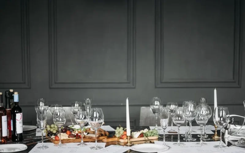 Two glasses of red wine sitting on a dark textured surface representing Barolo and Etna Rosso.