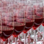 Two glasses of red wine on a wooden table during a vintage comparison tasting.