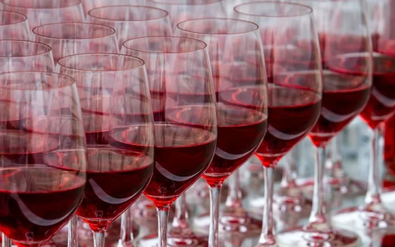 Two glasses of red wine on a wooden table during a vintage comparison tasting.