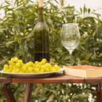 Glass of white wine on a table overlooking lush Midwest vineyard landscapes.