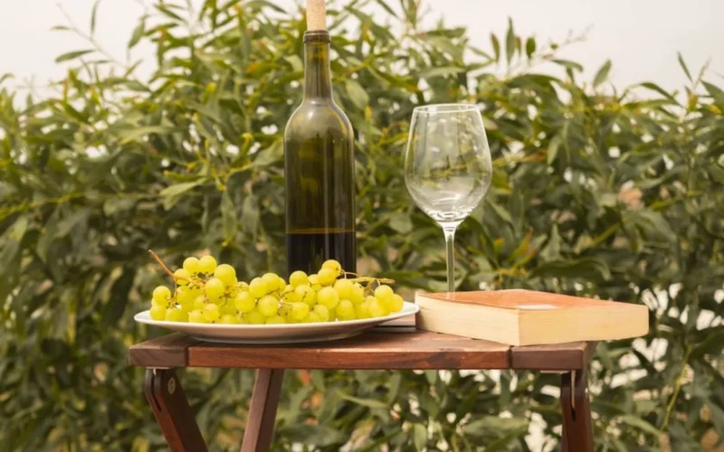 Glass of white wine on a table overlooking lush Midwest vineyard landscapes.