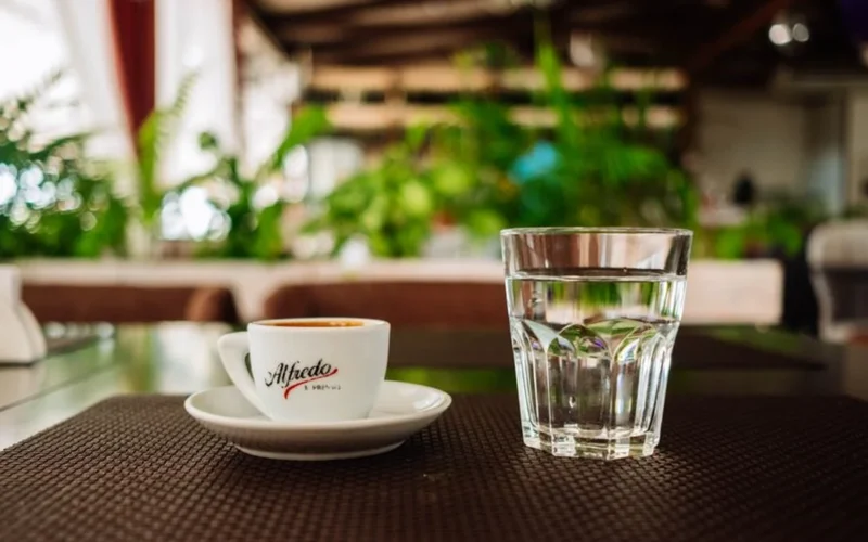 Assorted colorful coffee capsules arranged next to a fresh espresso shot on a kitchen counter.