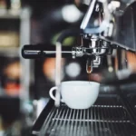 Close-up of fresh espresso being poured into a ceramic cup at a specialty coffee shop.