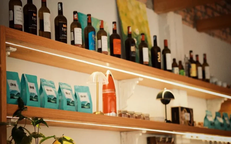 Close-up of various wine bottles arranged on wooden shelves inside a specialty retail store.
