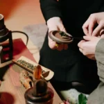 Traditional Chinese gongfu tea brewing tools with steam rising from small ceramic cups.