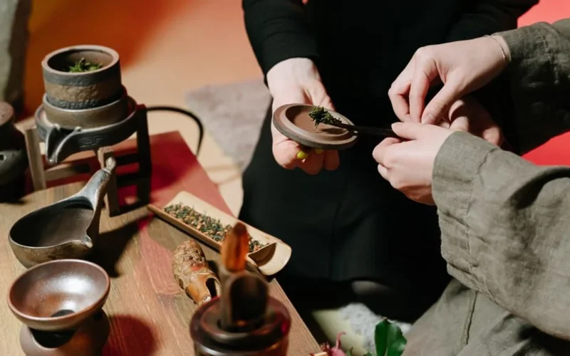 Traditional Chinese gongfu tea brewing tools with steam rising from small ceramic cups.