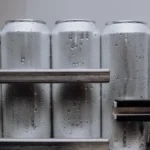 Aluminum ready to drink coffee cans moving through an industrial manufacturing facility.