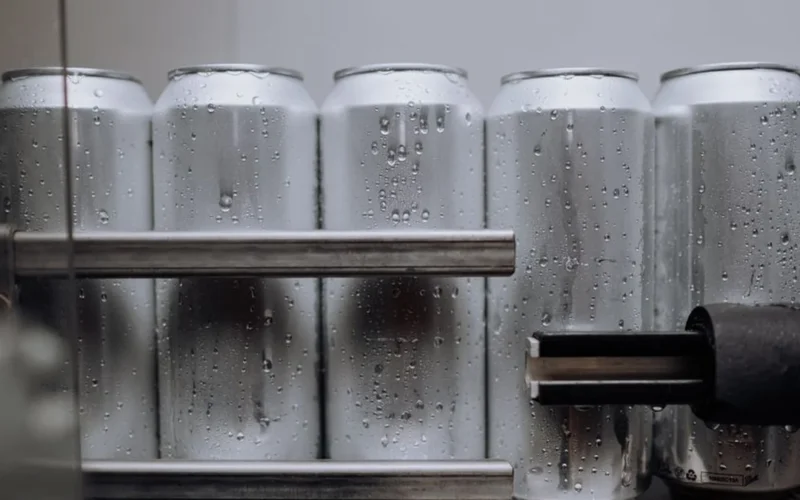 Aluminum ready to drink coffee cans moving through an industrial manufacturing facility.