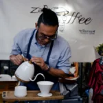 Pour over coffee being brewed with the Rocky Mountains in the background.