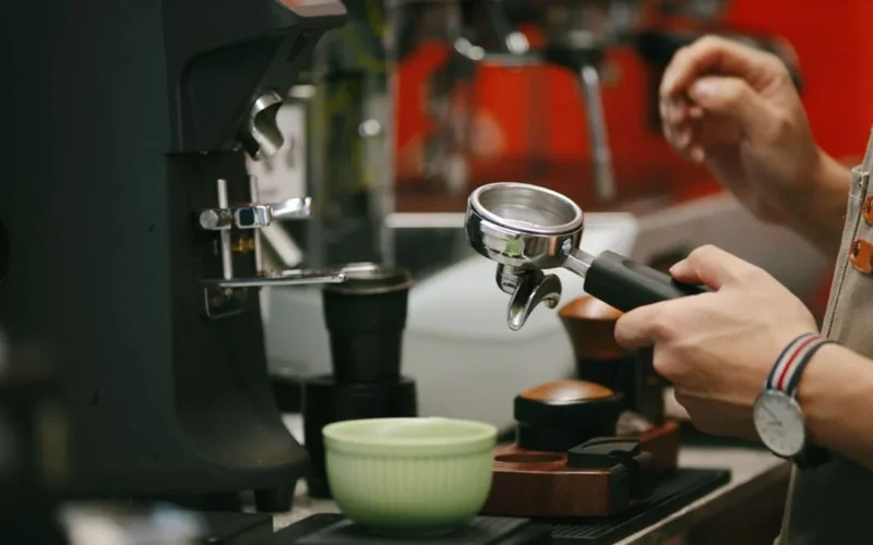 Two baristas serving specialty coffee to judges during a professional coffee competition.