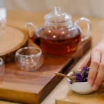 Various types of loose leaf tea and matcha powder in ceramic bowls.