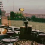A glass of red Pinot Noir paired with sourdough pizza on a wooden surface.