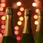 A bottle of English sparkling wine and a glass on a stone surface with chalk pebbles.