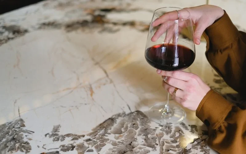 A glass of red wine on a marble table in a luxury Napa Valley winery.