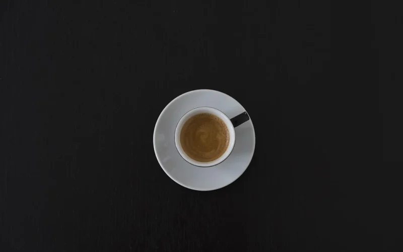 Overhead view of professional espresso tools and milk cartons organized on a coffee bar counter.