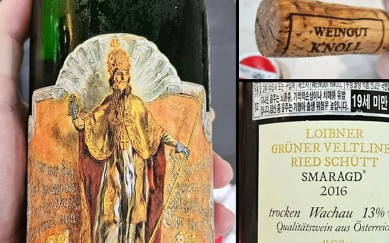 A glass of golden Grüner Veltliner wine next to dried apricots on slate.