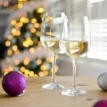 Pale golden Savagnin wine in a glass resting on textured grey stone.