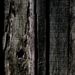 A close-up shot of a scarred and stained wooden work board in a winery cellar.