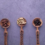 Traditional Somali spiced coffee with cardamom and cinnamon pods on a wooden table.