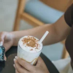 Person using a mobile app to order an iced specialty coffee drink