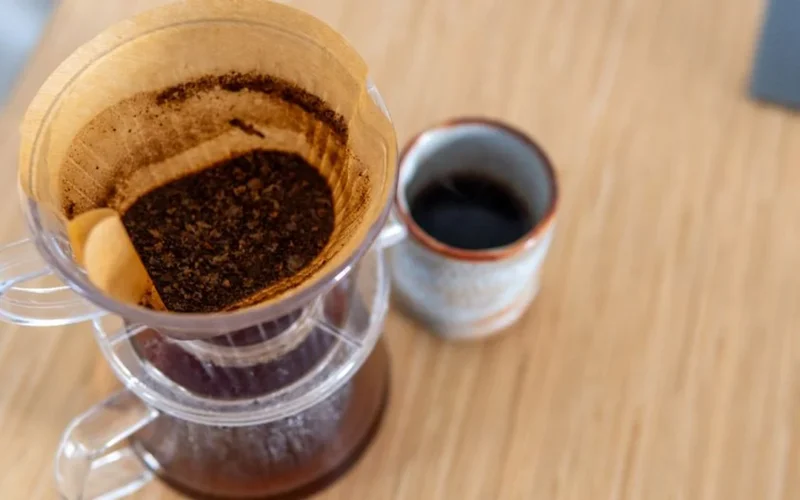 Close up of specialty coffee being poured into a reusable ceramic mug at a festival.