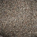 Raw green Arabica coffee beans spilling from a burlap sack on a dark wooden table.