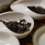 Close-up of amber Taiwanese oolong tea and traditional Japanese wagashi sweets on a ceramic plate.
