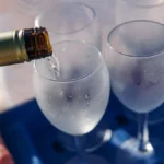 Close-up of white wine being poured into a glass at a wine bar.