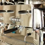 A stainless steel Breville Spiral Luxe automatic pour over coffee machine on a marble countertop.