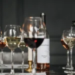 A set dining table with wine glasses and small plates at a coastal cafe.