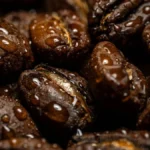 Macro close-up of textured dark roasted coffee beans with oily surfaces.