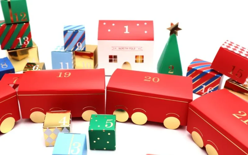 A colorful Kusmi Tea advent calendar open on a marble surface next to tea cups.