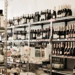 Rows of various wine bottles displayed on organized supermarket shelves in a grocery store.