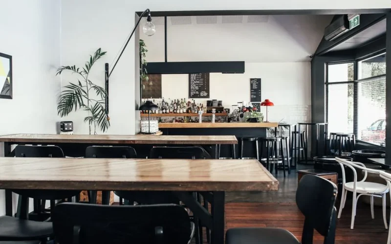 Sunny modern coffee shop interior with wooden tables and large windows in Orlando Florida.