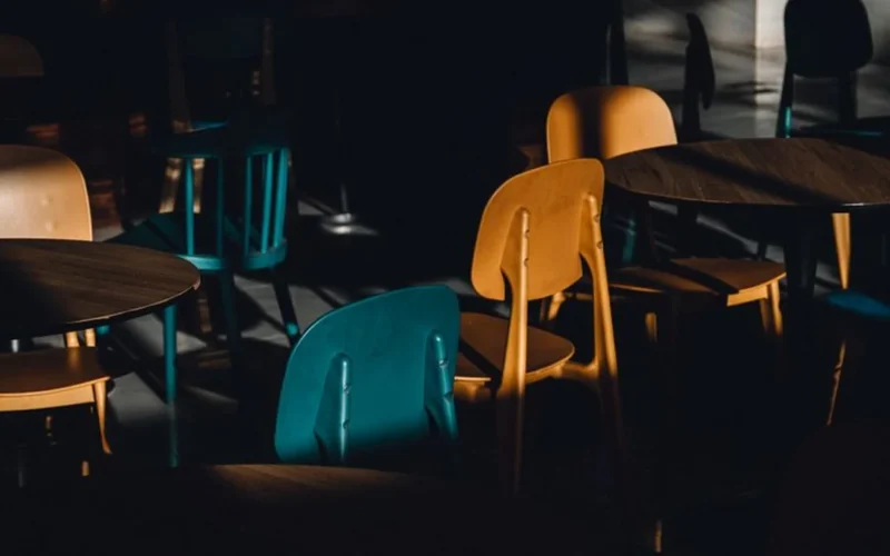 A sunlit corner of a local cafe with wooden tables and comfortable seating.